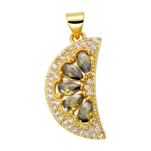 Macro detail of gold-plated lemon slice charm with green teardrop stones and zircon border