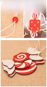 Detail of red and white wooden candy Christmas tree ornaments with twine and beads