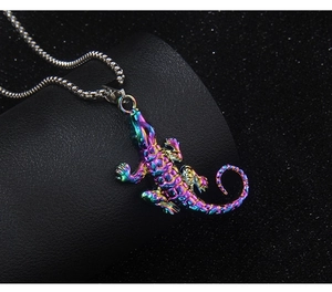Macro shot of colorful iridescent lizard pendant with textured scales on silver mesh chain