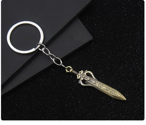 Detail of vintage bronze-tone metal sword keychain with intricate fantasy engravings