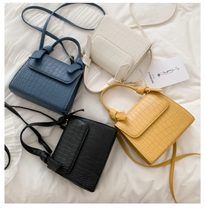 Flat lay of crocodile pattern crossbody bags in blue, white, yellow, and black colors