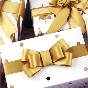 Christmas gift wrapping paper with gold satin ribbons and festive tree patterns