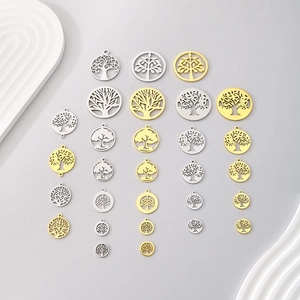 Multiple Tree of Life pendants in gold and silver finishes on a clean gray background