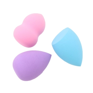 Detailed view of pink, purple, and blue makeup sponges in heart and teardrop shapes