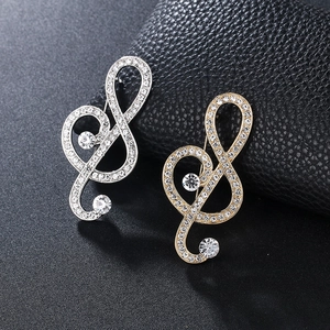 Luxurious musical treble clef brooch with sparkling rhinestones in gold and silver finish