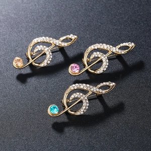 Luxurious gold music note brooches with sparkling crystals and colorful gemstones