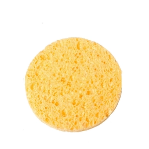 Close-up of a round yellow cellulose face sponge with porous texture on a white background