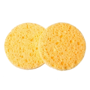 Detail showing two round yellow natural wood pulp sponges with porous texture for facial cleansing