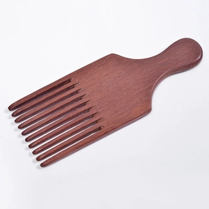 Macro detail of the natural reddish-brown wood grain texture on a wide-tooth Afro comb