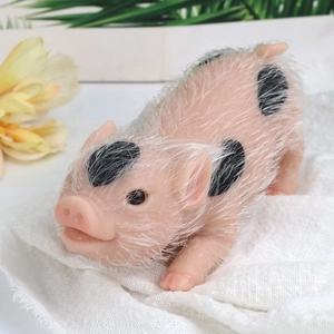 Macro shot of realistic pink spotted silicone piglet toy with soft flocked texture