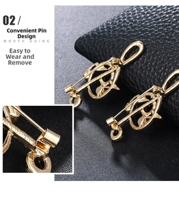 Detail view showing secure pin closure on the back of golden musical note brooch