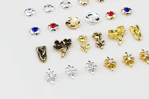 Macro shot of vintage 3D rose and star alloy nail art charms with colorful rhinestones