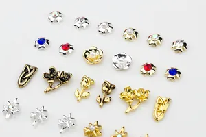 Macro detail of alloy nail art charms with vintage roses, stars and colorful rhinestones
