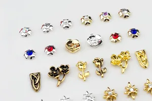 Macro detail of metal nail art charms with colorful rhinestones and pearl accents