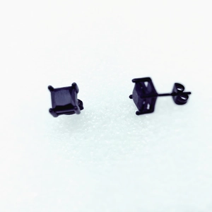 Close-up of black square zircon stud earrings with four-claw setting on black metal