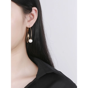 Minimalist S925 sterling silver gold pearl stud earrings worn by a model in close-up view