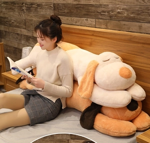 Large plush lying dog pillow shown in a cozy bedroom setting for comfortable sleeping