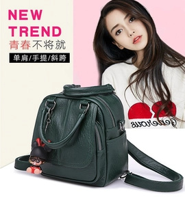 Detail of dark green leather versatile backpack featuring a cute cartoon doll pendant charm