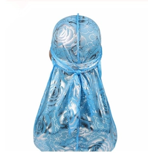 Detail view of silky blue durag with floral rose patterns and long ties on back