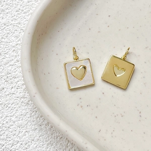 Close-up of heart-shaped gold pendants with mother-of-pearl inlay for DIY jewelry design