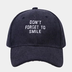 Navy corduroy baseball cap with 'Don't Forget To Smile' white embroidery on a gray background