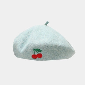 Close-up of light blue wool beret featuring exquisite red cherry embroidery detail