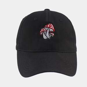 Close-up of fine red and white mushroom embroidery on a black cotton baseball cap