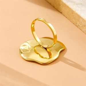 Minimalist gold-plated irregular lava ring displayed on a golden decorative tray
