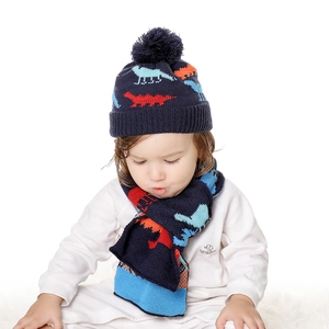 Detail shot of navy blue knitted dinosaur hat and scarf set with colorful pattern