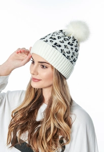 Close-up of leopard print knit beanie with fluffy white faux fur pom-pom and ribbed cuff