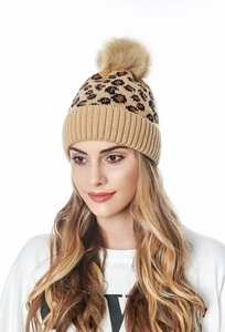 Detail of knit leopard print beanie featuring a fluffy brown faux fur pom pom on top