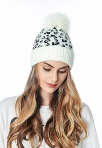 Detail shot of winter leopard knit beanie with soft white faux fur pompom and ribbed cuff