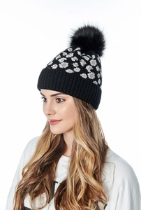 Detail view of winter leopard knit beanie with a large fluffy faux fur pompom for women