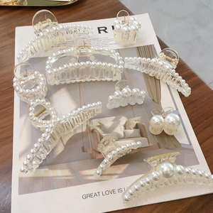 Elegant pearl hair claw clip set made of clear acrylic with white pearls on a magazine base
