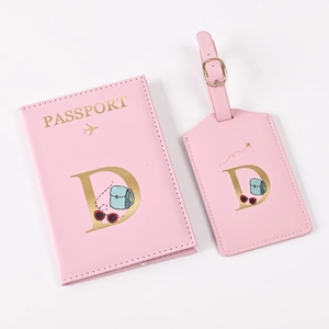 Pink passport cover and luggage tag set with gold letter D and travel motifs