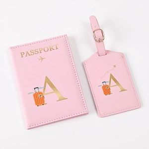 Detail of pink PU leather passport holder and luggage tag set with gold letter A design