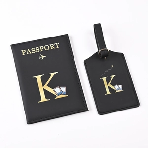 Close-up of black PU leather passport holder and luggage tag set with gold letter K
