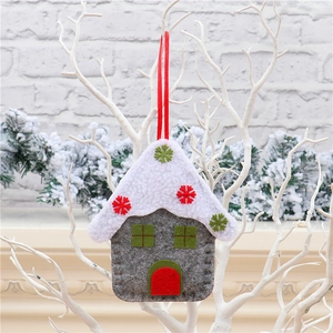 Detailed view of gray and white felt house ornament with snowflake decor on branch
