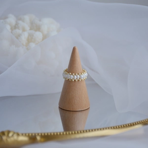 Detailed view of natural freshwater pearl and 14k gold plated ring on wood stand