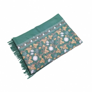 Detail of green pashmina shawl with golden floral embroidery and fringed tassels