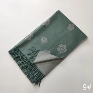 Detail of camellia floral cashmere scarf with reversible design and fringe tassels