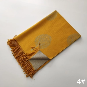 Detailed view of yellow and beige cashmere scarf with tree jacquard patterns and tassels