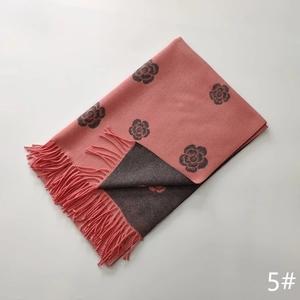 Close-up of pink and dark grey double-sided cashmere scarf with flower patterns and tassels