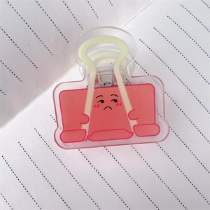 Primo piano della clip in acrilico rosa con faccia buffa su carta a righe