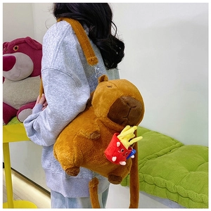 Detailed view of Capybara plush backpack with red french fries accessory on model back