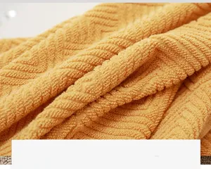Detailed macro view of soft yellow cotton towel featuring premium herringbone texture weave