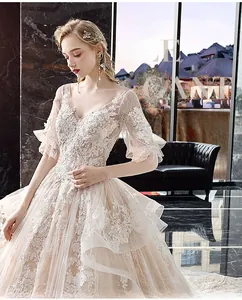 Detailed embroidery and ruffle sleeves on elegant V-neck champagne bridal gown
