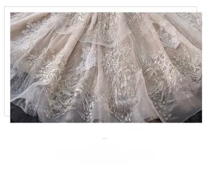 Detail of champagne bridal gown showing intricate lace embroidery on tulle train