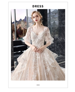 Detail of champagne lace wedding dress with deep V-neck and 3D floral embroidery textures