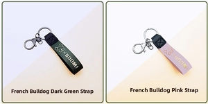 Detail view of dark green and pink leather bulldog keychains with metal clasps